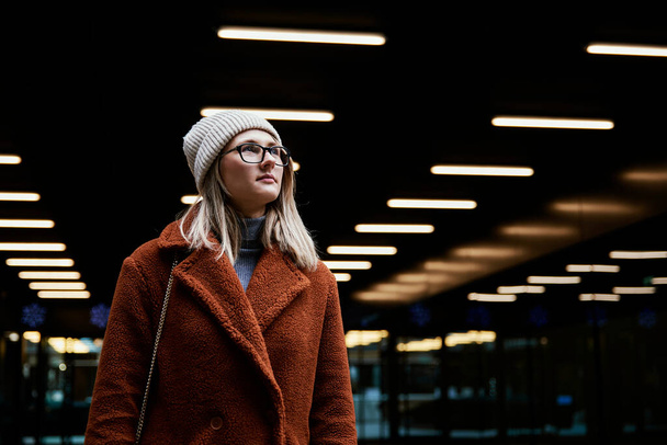 Woman in coat walks at city stret - Fotó, kép