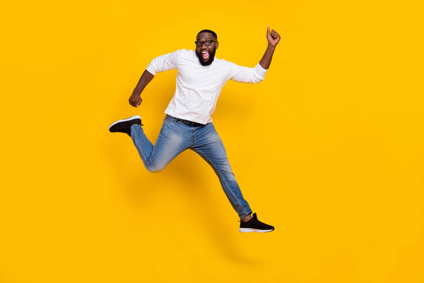 Full body photo of excited amazed sporty guy have fun rejoice free time isolated on yellow color background - Fotó, kép
