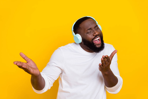 Photo of excited overjoyed guy listen to pop bass sound chill entertainment isolated on yellow color background - Photo, Image