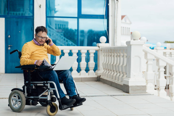 mężczyzna niepełnosprawny na wózku inwalidzkim pracuje na laptopie w Internecie - Zdjęcie, obraz