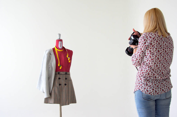 A female photographing a mannequin with cute autumn clothes isolated on a white background - Foto, immagini