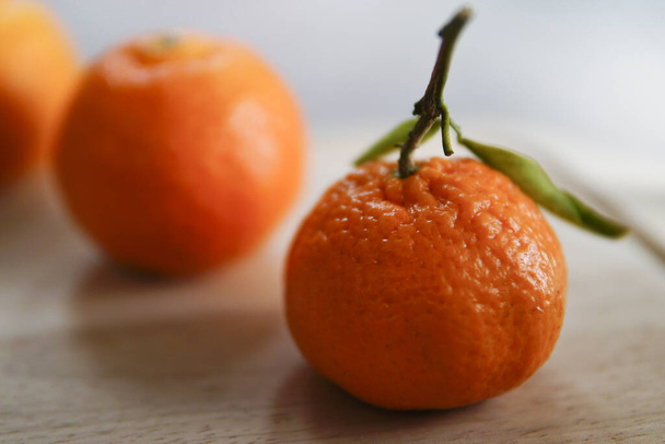 A close up shot of a fresh orange on the wooden table with blurry background - Photo, image