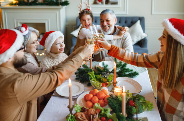 Szczęśliwy duży wielopokoleniowa rodzina cieszyć się kolacją xmas, brzęczenie okulary podczas świąt Bożego Narodzenia - Zdjęcie, obraz