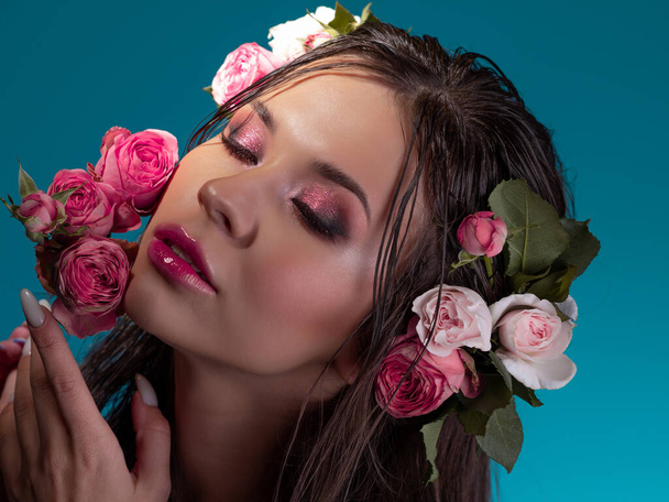 Luxury portrait of a beautiful young woman with roses and fresh bright makeup - Photo, image