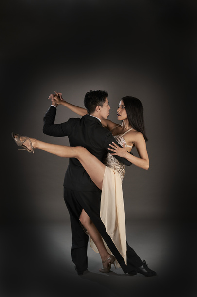 Latin kadın ve Asyalı erkek tango dansı yapıyor. Stüdyo çekimi - Fotoğraf, Görsel