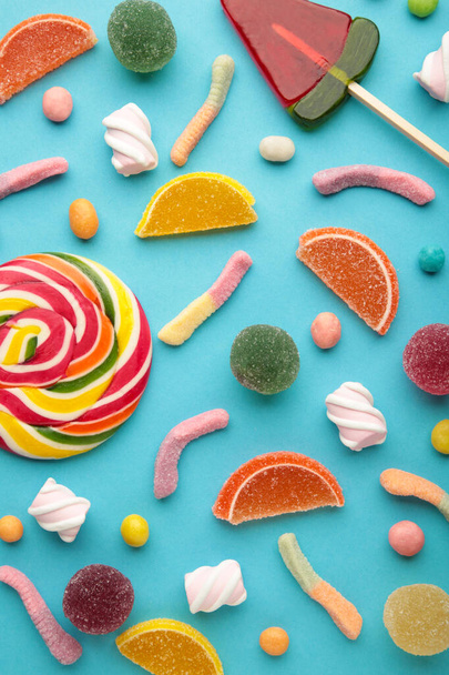 Colorful candies lollipops and jelly on pink background. Top view. Vertical photo - Foto, afbeelding