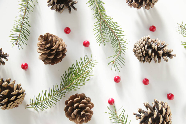 Karácsonyfa ágak, tűlevelű toboz és piros bogyók felső nézet fehér háttér. Karácsony, téli ünnep, újévi koncepció. - Fotó, kép