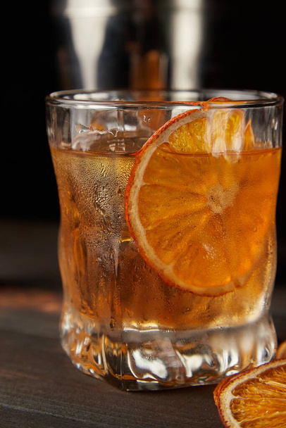 Old fashioned cocktail up close on a wooden background - Foto, afbeelding