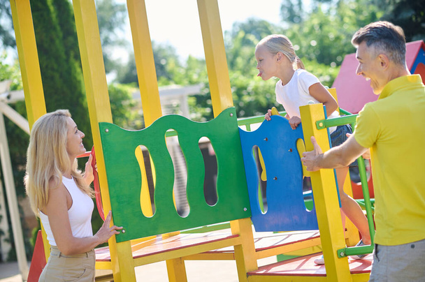 Family spending time at the playground and looking enjoyed - Fotoğraf, Görsel