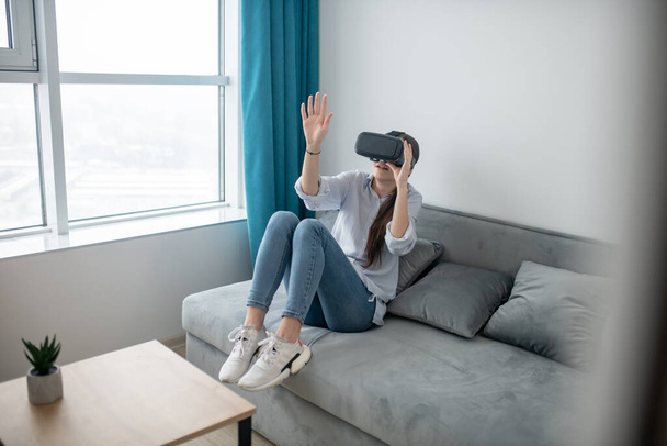Caucasian female in VR goggles exploring virtual reality - Фото, изображение