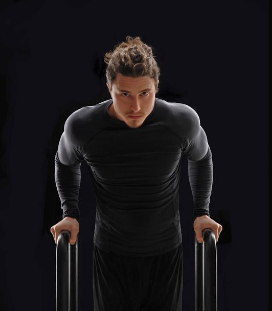 Free body workout portrait man on calisthenic parallel bars. - Foto, Imagen
