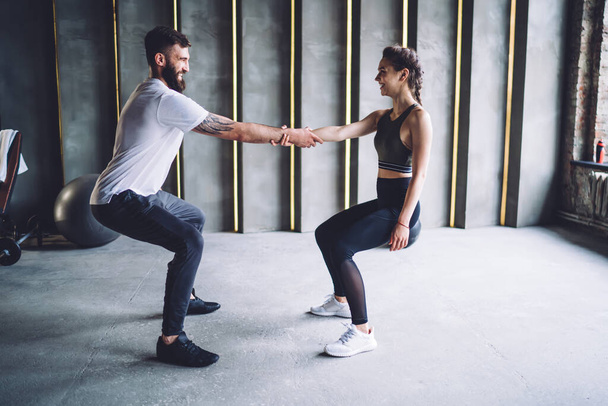 Happy caucasian male and female athletes enjoying resultative workout spending time in gym, positive woman and man athletes satisfied with healthy active lifestyle and reaching fitness goals - Fotoğraf, Görsel