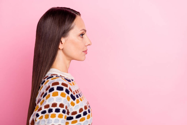 Photo of serious confident young woman wear dotted sweater looking empty space isolated pink color background - Φωτογραφία, εικόνα