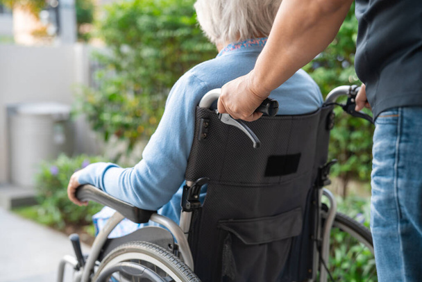 Verzorger hulp en zorg Aziatische senior of oudere oude dame patiënt zit op rolstoel op verpleegkundige ziekenhuis afdeling, gezond sterk medisch concept - Foto, afbeelding