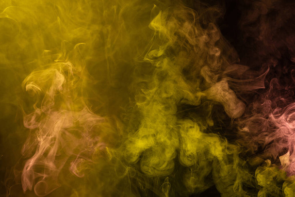Yellow and pink steam on a black background. Copy space. - Foto, afbeelding