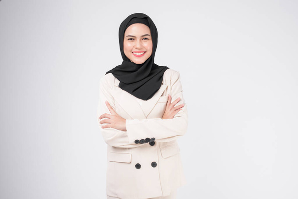 Portrait of young smiling muslim businesswoman wearing suit with hijab over white background studio.	 - Foto, Imagen