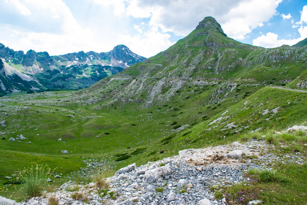 Berggipfel des Durmitor-Nationalparks, entlang dessen malerische hochgebirgige Touristenstraße Nordmontenegros verläuft. UNESCO-Weltkulturerbe. Schöne sommerlich bewölkte Landschaft. - Foto, Bild