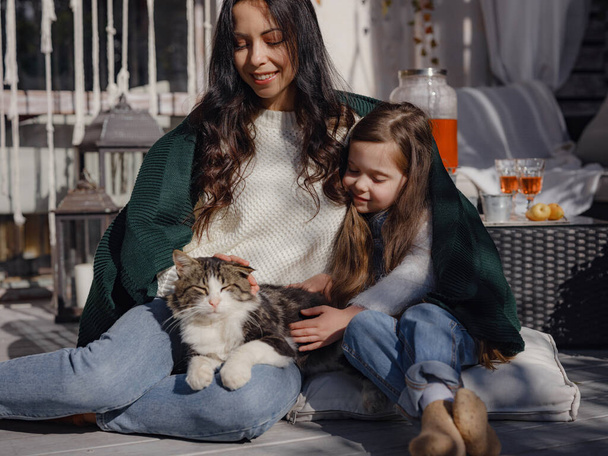 Маленькая счастливая семья празднует День Благодарения. милый забавный малыш и кот. Сбор подарков осенью. сельская жизнь. Родительство маленькие моменты, объятия и кошка - Фото, изображение