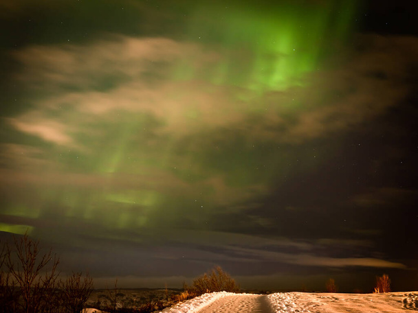 Zielone światła północne nad miastem Hafnarfjordur, Islandia. Zimowa noc, bez ludzi..  - Zdjęcie, obraz