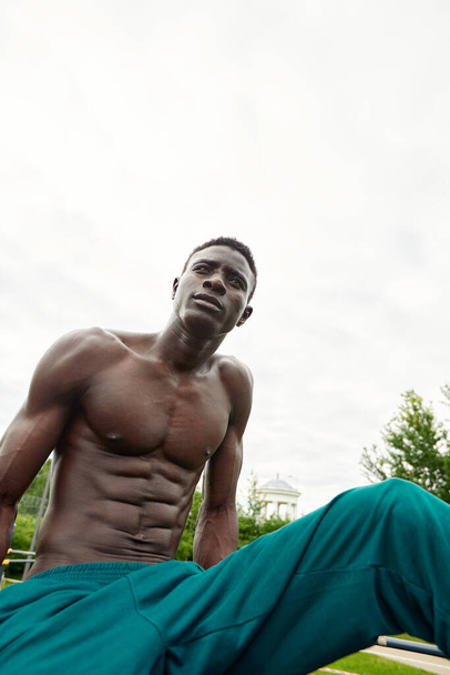 Muscular african man doing push ups in the park. Strong male athlete working out outdoors. - Zdjęcie, obraz