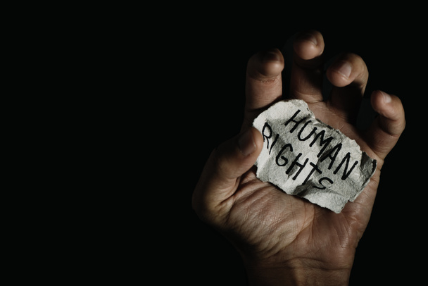 um homem tem um pedaço de papel na mão com o texto direitos humanos escrito nele - Foto, Imagem