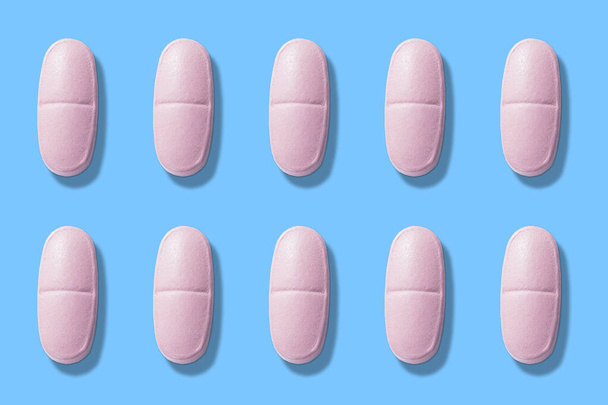 Pink pills on a blue background. pink pills on blue background top view - Foto, imagen
