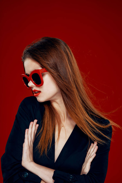 pretty woman wearing sunglasses fashion posing hairstyle red background - Photo, Image