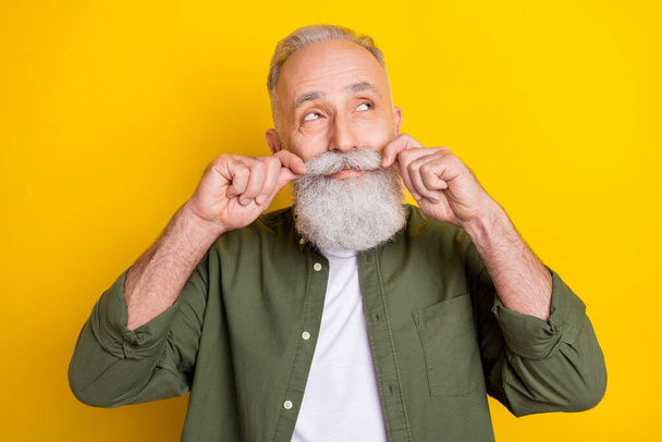 Photo portrait of senior man touching mustache looking dreamy empty space isolated vibrant yellow color background - Valokuva, kuva