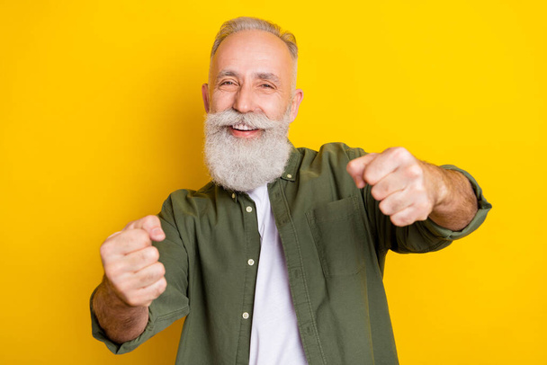 Photo portrait of grandfather imagine driving a car isolated vibrant yellow color background - Foto, imagen