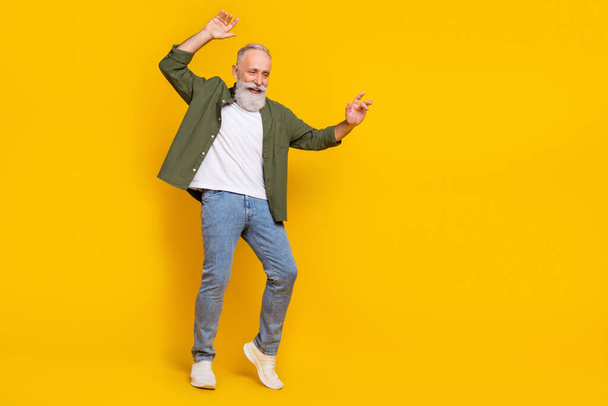 Full length body size photo of dancing senior man wearing casual clothes laughing isolated on vivid yellow color background - Фото, изображение