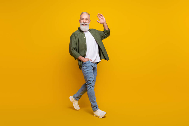 Full length body size photo of positive happy senior man smiling waving hand isolated vivid yellow color background - Fotoğraf, Görsel