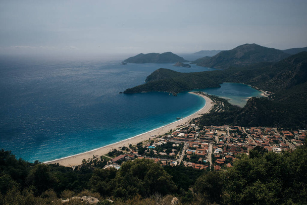 Oludeniz blaue Lagune und Sandstrand in Fethiye, Türkei. Türkisfarbene Küste im Südwesten der Türkei, aufgenommen auf dem lykischen Wanderweg bei sonnigem, hellen Tag mit blauem Himmel in Oludeniz. Hochwertiges Foto - Foto, Bild