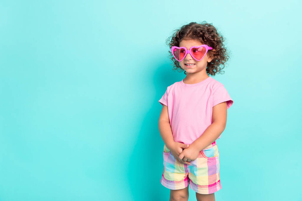 Portrait of attractive cheerful shy girl wearing big pink specs thinking copy space isolated over bright teal turquoise color background - Fotografie, Obrázek