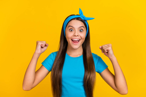 Photo of young excited girl rejoice victory fists hands lucky triumph discount isolated over yellow color background - Foto, Imagem
