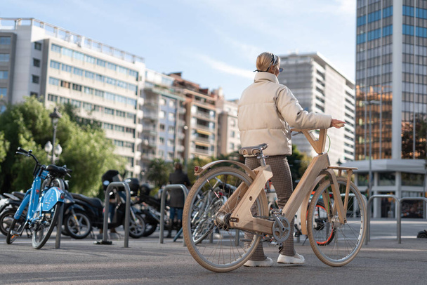 Жінка з велосипедом біля парковки
 - Фото, зображення