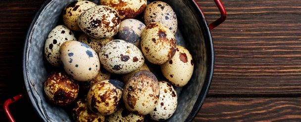 Quail eggs in metal plate on dark old background. Rustic style. Top view - Photo, Image