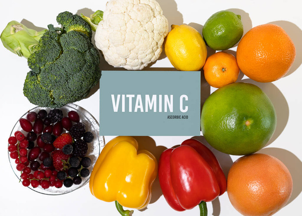 Un conjunto de productos naturales ricos en ácido ascórbico de vitamina C. Concepto de comida saludable. Signo de cartón con la inscripción. - Foto, imagen