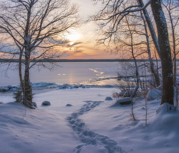 Snow trail to the lake under ice at sunset. Winter landscape. - Foto, Imagen