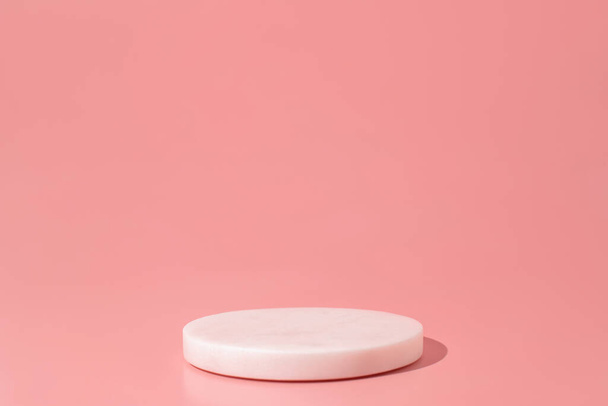 White marble podium on the pink background. Podium for product, cosmetic presentation. Creative mock up. Pedestal or platform for beauty products. - Foto, Imagem