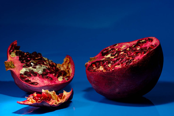 Geschälter natürlicher Bio-Granatapfel auf blauem Studiohintergrund - Foto, Bild