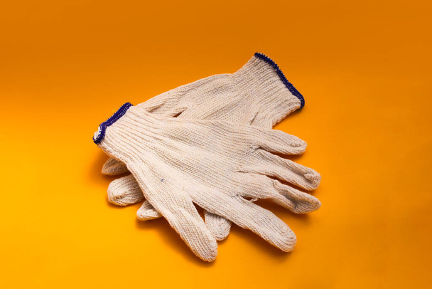 White Gardening gloves isolated on orange background - Photo, Image