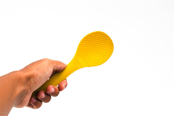 an Asian man holding a Yellow plastic rice spoon isolated on white background - Photo, Image