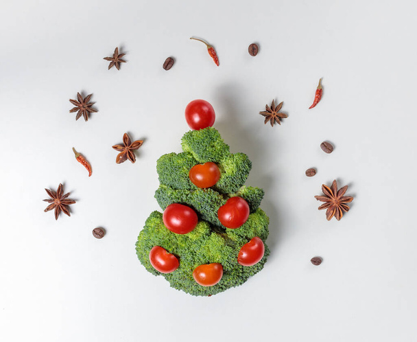 O conceito do ano novo, alimentação saudável, consumo consciente. Brócolis Árvore de Natal decorada com tomates cereja - Foto, Imagem