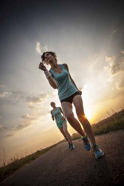 twee mooie meisjes joggen in de ochtend - Foto, afbeelding