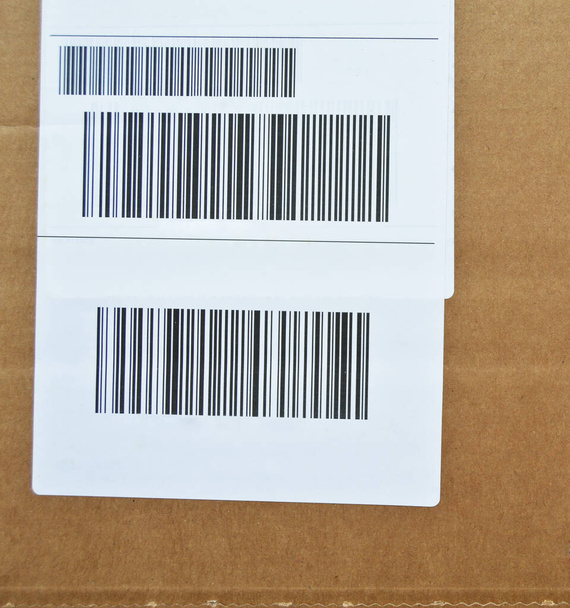 Brown and beige cardboard paper mail envelope on sticky barcodes. Can be used in company correspondence - Zdjęcie, obraz