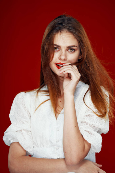 allegra donna dai capelli rossi con labbra rosse vestito bianco sfondo rosso - Foto, immagini
