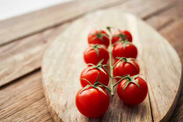 cherry tomatoes on a branch on a wooden board kitchen ingredient fresh food - Foto, Imagen