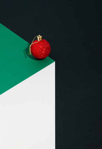 3D-Rendering von roter Christbaumkugel auf Papierwürfel. Trendige Weihnachten Design Farbe Hintergrund. Neujahrskonzept. Abstrakte Komposition. - Foto, Bild