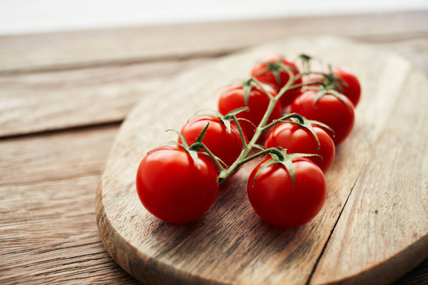cherry tomatoes on a branch on a wooden board kitchen ingredient fresh food - Photo, image