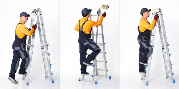 シニアアジアの男は、金属の背の高いはしごと画家の労働としてオレンジの均一なシャツの帽子と手袋を着用。短い小さな男性ホールドブラシ塗装ローラー多くのビューの完全な長さ、白い背景孤立 - 写真・画像